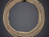 un collier en or et en argent avec un fermoir carré sur fond noir