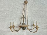 a chandelier hanging on the wall with three candles