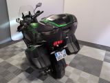 a black and green motorcycle parked on a checkered floor
