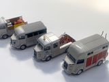 trois camions miniatures alignés sur une surface blanche