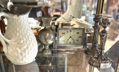 une vitrine sur laquelle sont posés une horloge et un vase