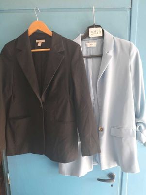 deux vestes accrochées l'une à côté de l'autre sur une porte bleue