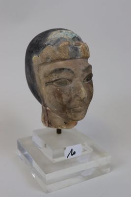 une statue représentant la tête d'une femme, posée sur un socle transparent