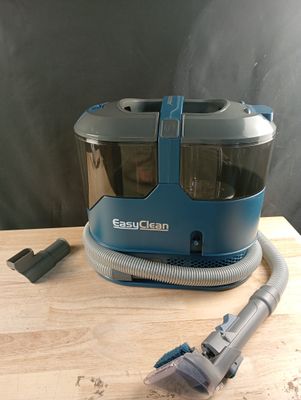 un aspirateur posé sur une table, à côté d'un cordon d'alimentation
