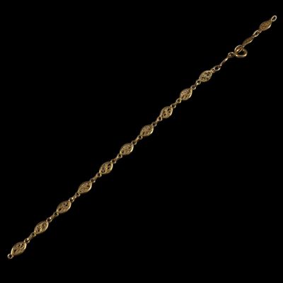 a close up of a gold bracelet on a black background