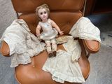 a doll that is sitting on a chair in a chair
