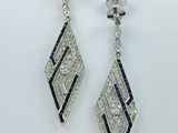 une paire de boucles d'oreilles en diamants et saphirs sur fond blanc