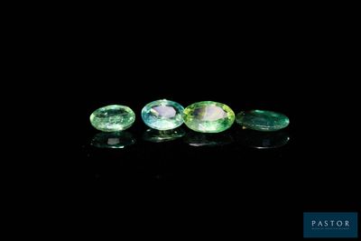 three green tourmaline gems on a black background