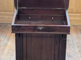a small wooden chest on a stand in a room