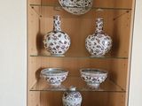 de nombreux vases et bols posés sur une étagère dans un meuble