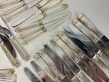 a lot of silverware on a table with a knife and fork
