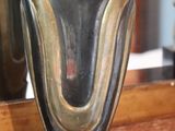 a silver vase sitting on a table in front of a mirror