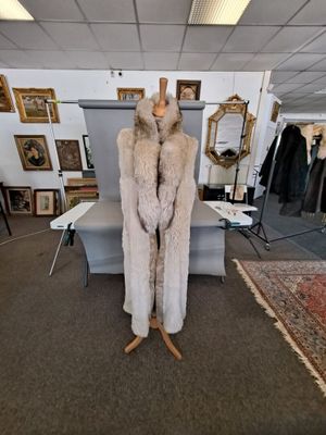 un manteau de fourrure posé sur un pied de mannequin dans une pièce