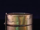 a close up of a gold ring on a black surface