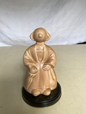 une petite figurine représentant un homme assis sur une table