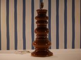 a lamp that is sitting on a table in front of a striped wall