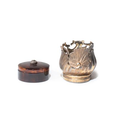 un vase en argent et une boîte en bois posés sur une surface blanche