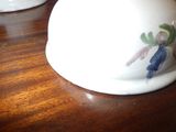 a white bowl with a flower on it on a wooden table