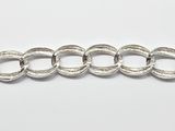 gros plan d'un bracelet en argent sur une surface blanche