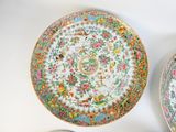 two plates with floral designs on them sitting on a table