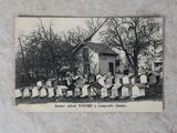 une photo en noir et blanc d'un groupe de personnes devant un cimetière