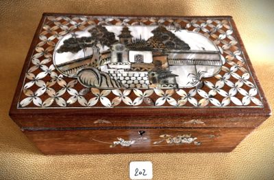 a wooden box with a painting on it sitting on a table