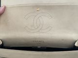 someone is holding a chanel purse in their hand
