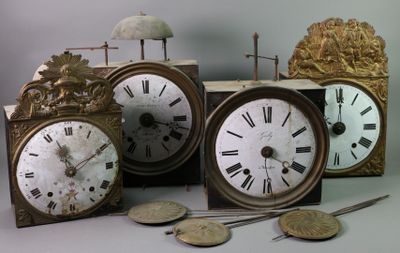 four different clocks sitting next to each other on a table