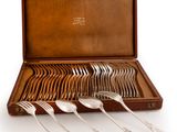 a set of silverware in a wooden case on a white background