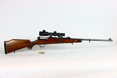 un fusil sur fond blanc, avec un point rouge sur le côté du fusil