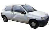 a small white car that is parked on the side of the road