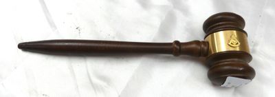 un marteau de juge en bois posé sur un drap blanc