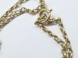 an image of a close up of a gold chain with a heart on it