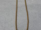 a gold necklace with a heart shaped pendant on it