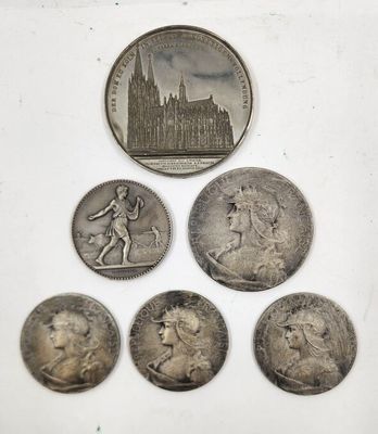 un groupe de cinq pièces d'argent posées sur une surface blanche
