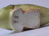 a figurine of a fish on a white surface