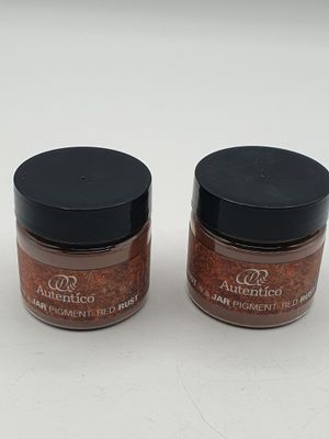 two jars of spices sitting on top of a white surface