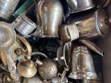a large pile of silver pots and pans in a bin