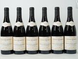 six bottles of wine are lined up in a row on a table