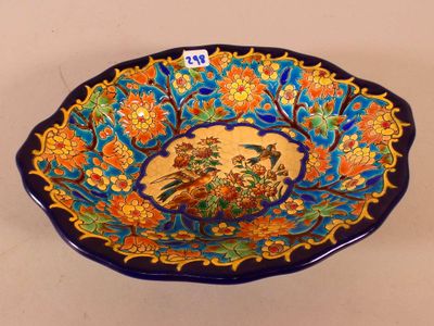 a blue bowl with a bird and flowers on it