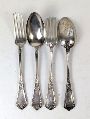 quatre cuillères et une fourchette sur une table blanche