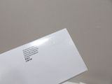 a person holding a white envelope in their hand