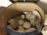 a bucket full of dishes and plates on a table
