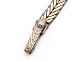 a close up of a silver tie bar on a white surface