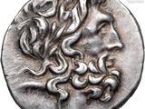 a close up of a silver coin with a face on it