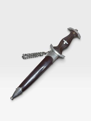 a close up of a knife on a chain on a white background