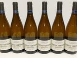 six bouteilles de vin sont alignées sur une surface blanche