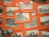 de nombreuses vieilles photos posées sur une table sur laquelle se trouve un chapeau