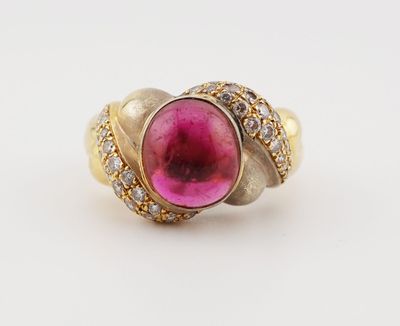 a close up of a gold ring with a pink stone surrounded by diamonds