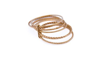 a close up of a stack of gold rings on a white background